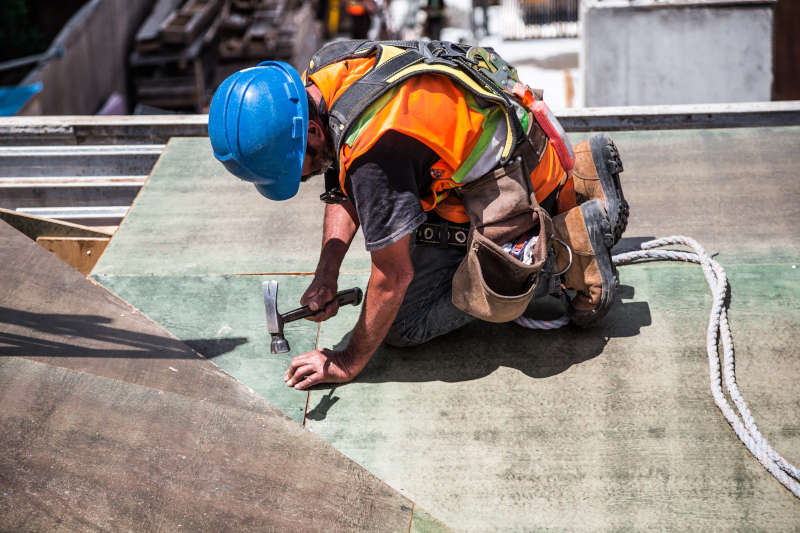 roofer roofer with orange vest and blue hat